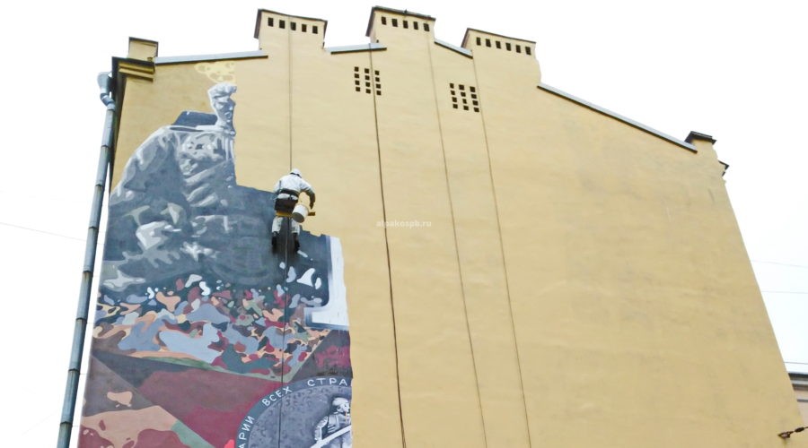 Пром альпинист красит стену здания на высоте 2