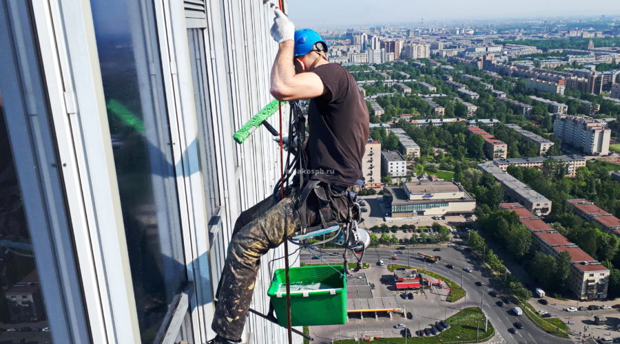 Промышленный альпинист моет окно на большой высоте