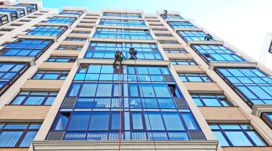 Промышленные альпинисты моют окна жилого здания